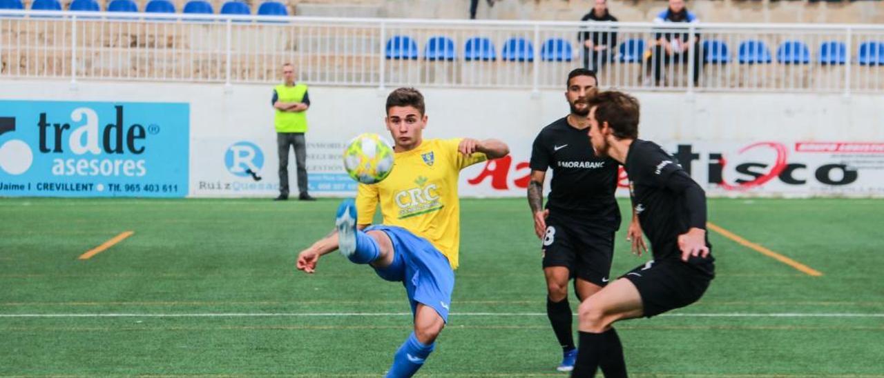 Pitu intenta despejar un balón ante dos jugadores del Andorra.