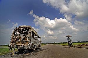 Un autobús cremat en una carretera del districte de Kamrup, a 55 km de Guwahati, a la regió d’Assam, Índia. Milers de persones van tornar des de diferents punts de l’Índia al nord-est del país, d’on eren originàries, per por de patir matances com les registrades setmanes enrere en aquella zona.
