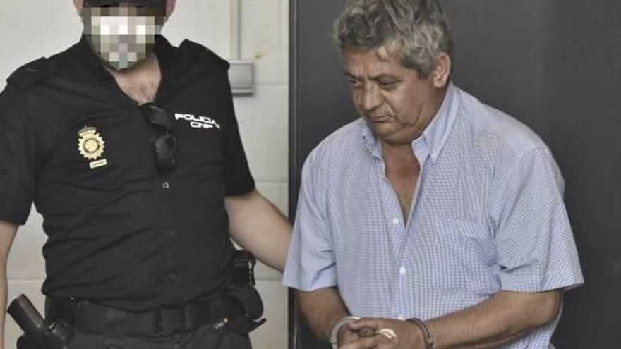 Un agente con el detenido, acusado de matar a su mujer.