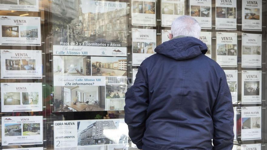 Un hombre delante del escaparate de una inmobiliaria en Vigo.   | // RICARDO GROBAS