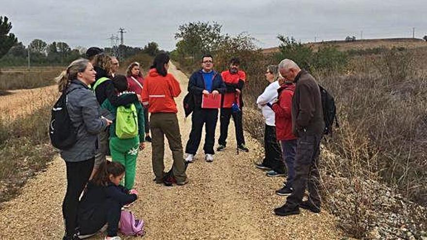 Los participantes en la conmemoración del Día de la Ruta de la Plata escuchando las explicaciones históricas del trazado y caminando por el antiguo itinerario del ferrocarril.´A. G.