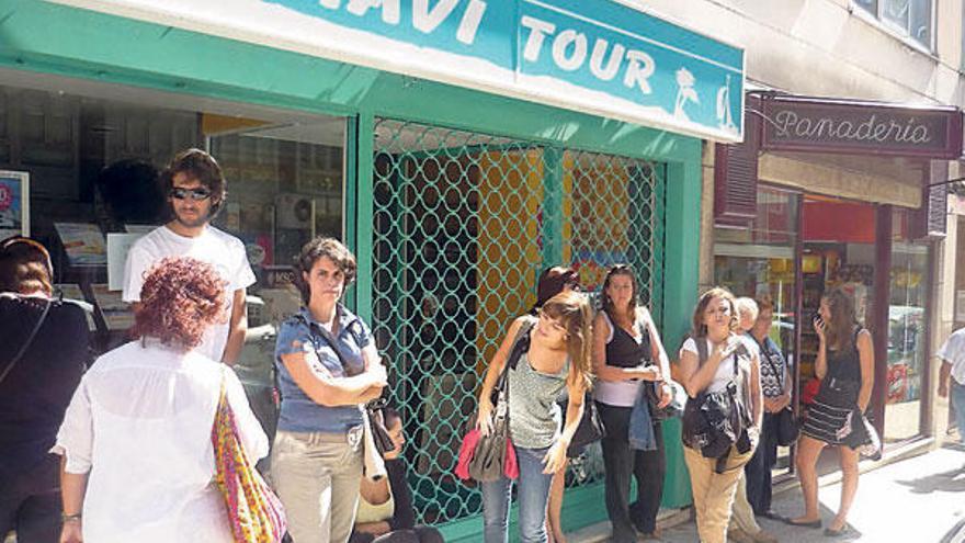 Los afectados, ayer, a las puertas de la agencia de viajes en Santiago.  // FDV