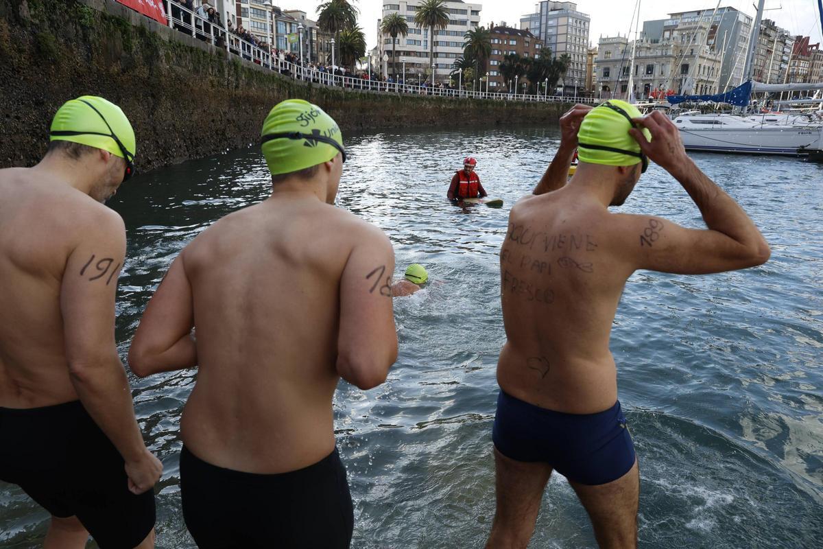 La travesía a nado de Navidad en Gijón congrega un año más a decenas de participantes (en imágenes)