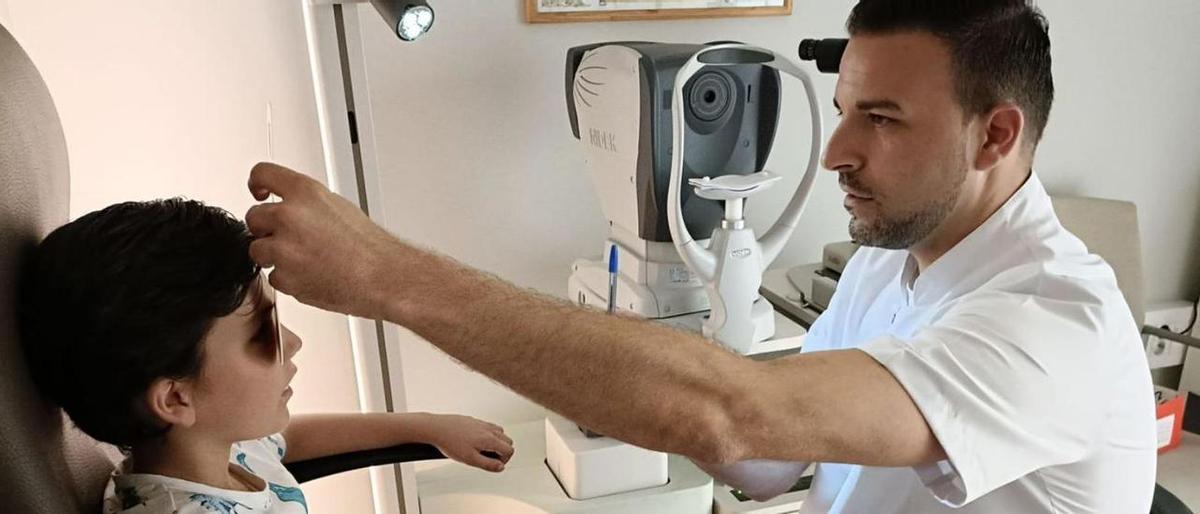 Miguel de Francisco, de la óptica Lunic, gradúa la vista ayer a un niño.