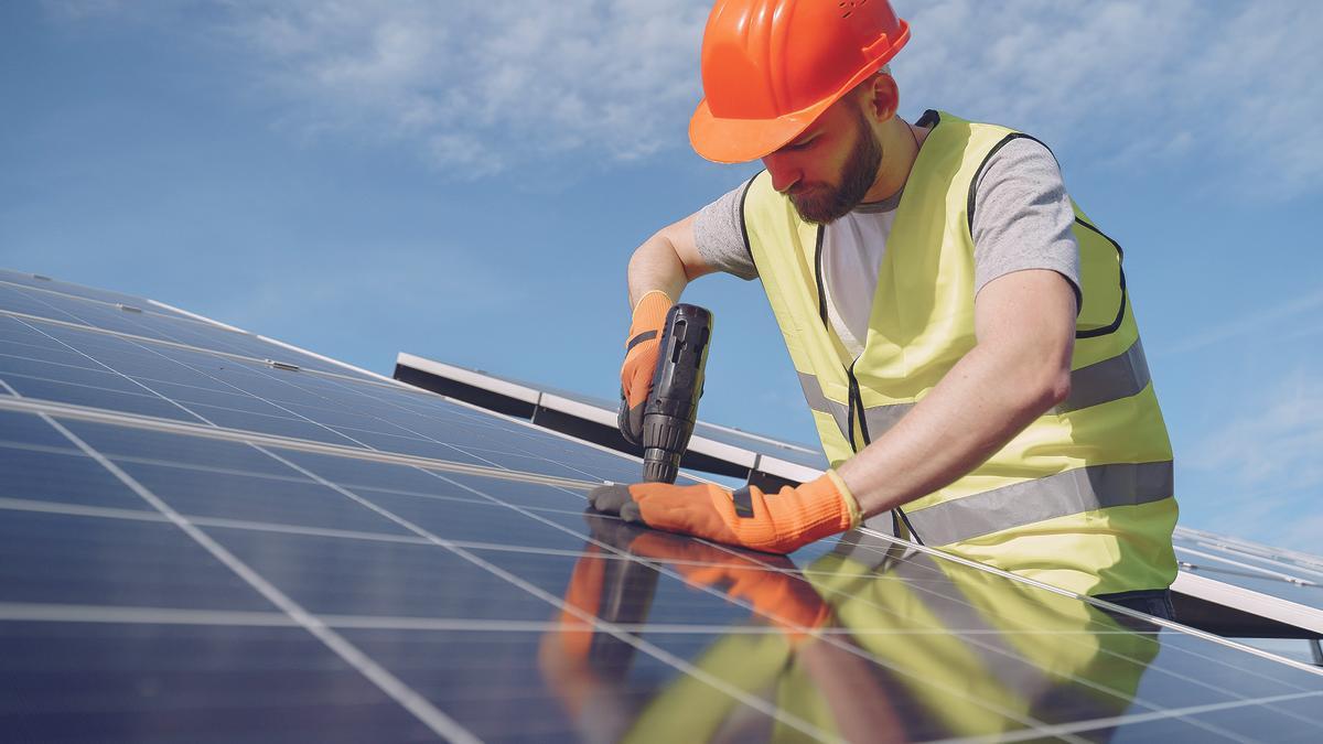 Un especialista coloca placas fotovoltaicas en una instalación solar.