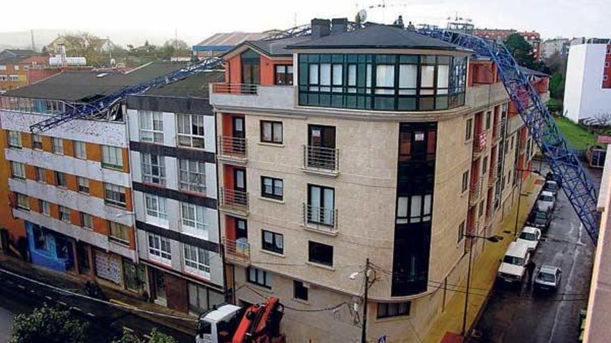 Una grúa de obra se desplomó sobre un edificio de la villa coruñesa de Carral.