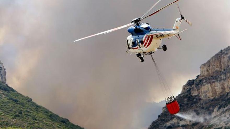 Un helicóptero en labores de extinción del incendio forestal que se ha declarado hoy en el término municipal de Jaulín (Zaragoza) y que ha obligado a evacuar tres urbanizaciones.