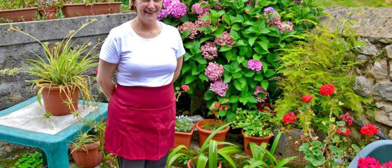 Ángela García Calleja, en uno de los rincones exteriores de su local, lleno de flores, en Ardisana.