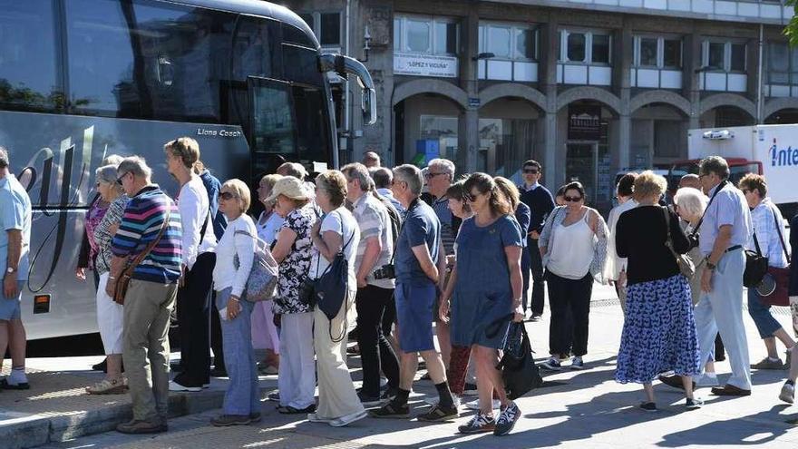 Turistas esperan para subir a un bus, en Puerta Real.