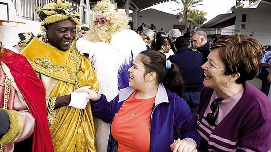 Niños, trabajadores y familiares aplauden a sus majestades.