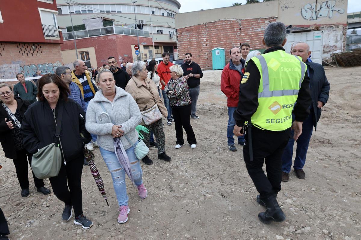 Las familias expropiadas de Barriomar frente a su casas y ante la mirada de los guardias de seguridad.