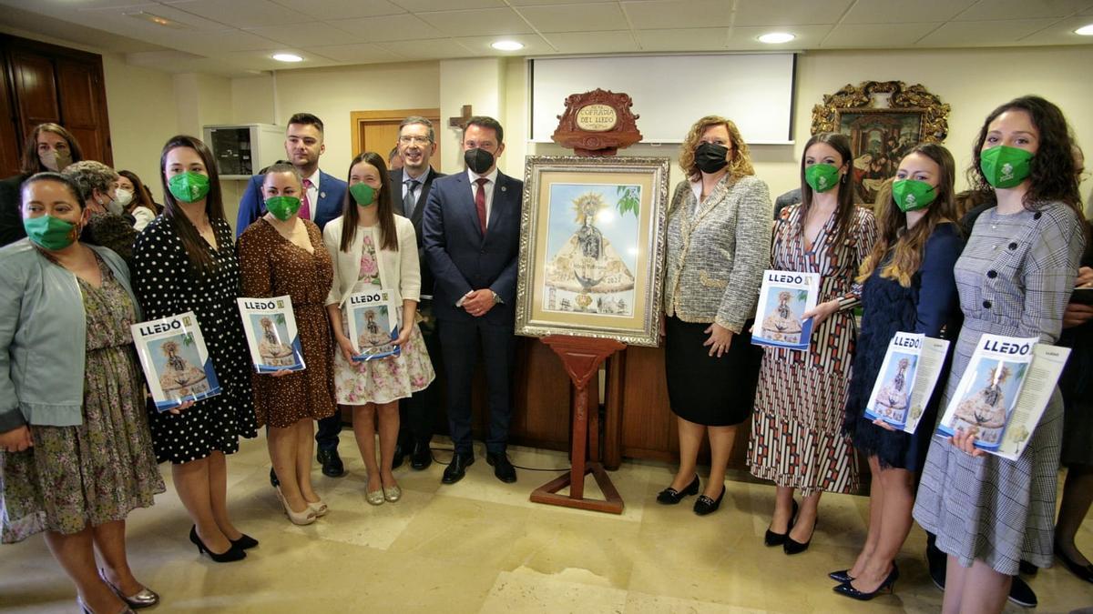 Reinas, presidentes y la edil Pilar Escuder, junto al cartel de Luis Fabra.