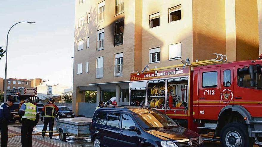 Bomberos y Policía Municipal durante las labores de extinción del incendio del piso situado en Pinilla.