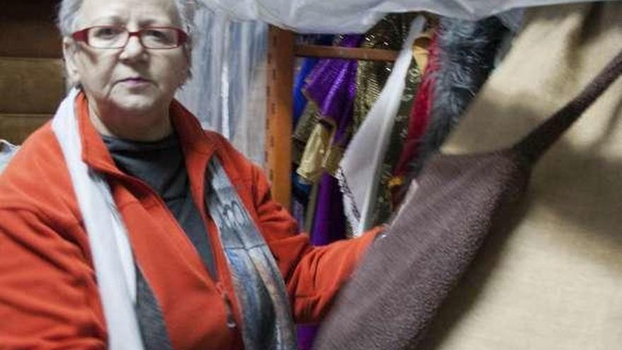 María Jesús Fernández muestra uno de los 300 trajes para la cabalgata que guardan en su sede.