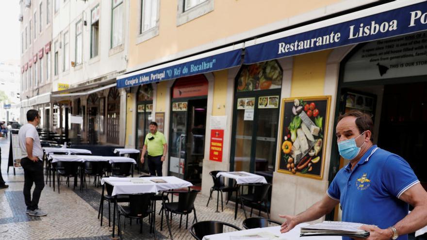 Un camarero prepara una mesa en Lisboa.