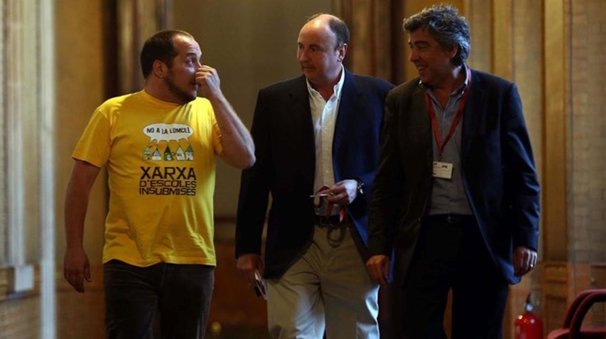 David Fernàndez, con una camiseta a favor de las escuelas insumisas con la ’ley Wert’, acompaña a A.G.K., empresario de Life Mataró (centro), y a su abogado, en la ’comisión Pujol’, el 4 de mayo.