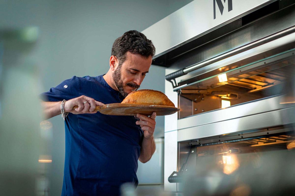 Vélez sacando un pan recién hecho del horno