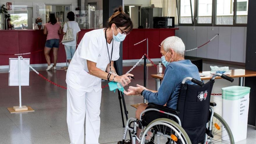 Un sanitario con un anciano en Menorca.