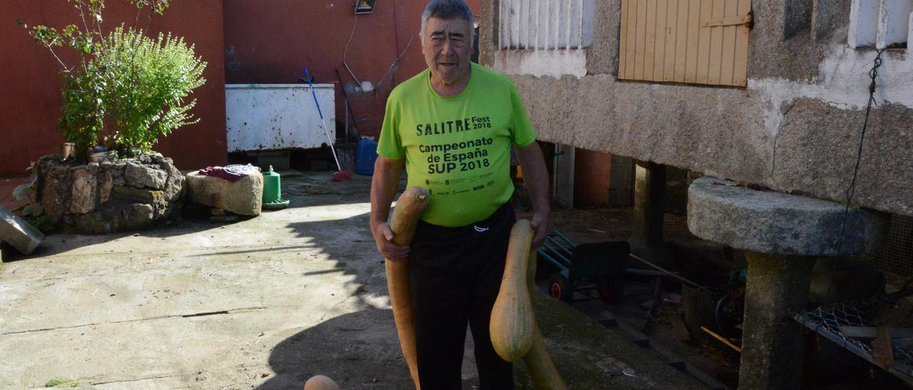 Jesús Fernández con dos de sus calabazas gigantes, en su casa de Bueu.