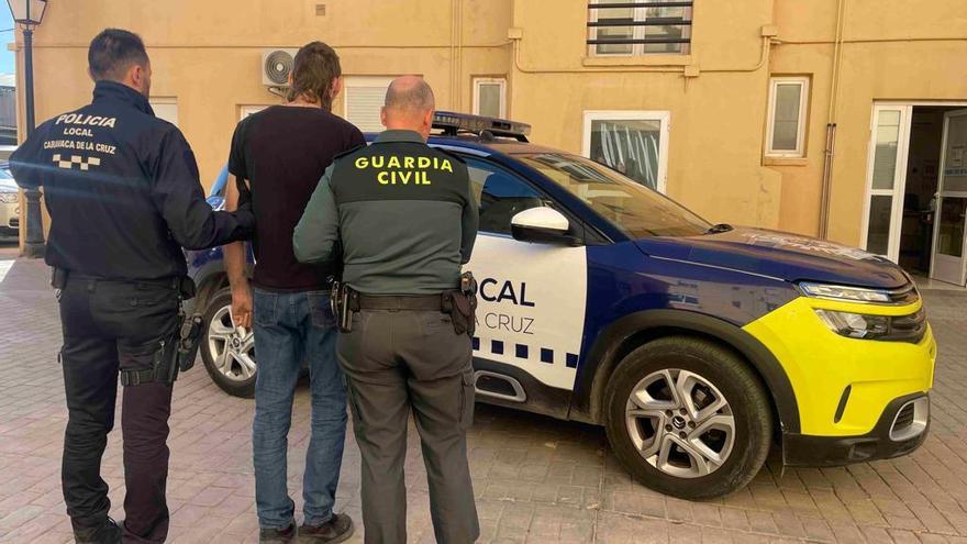 Un policía y un guardia civil conducen a uno de los sospechosos a un vehículo policial de Caravaca de la Cruz.