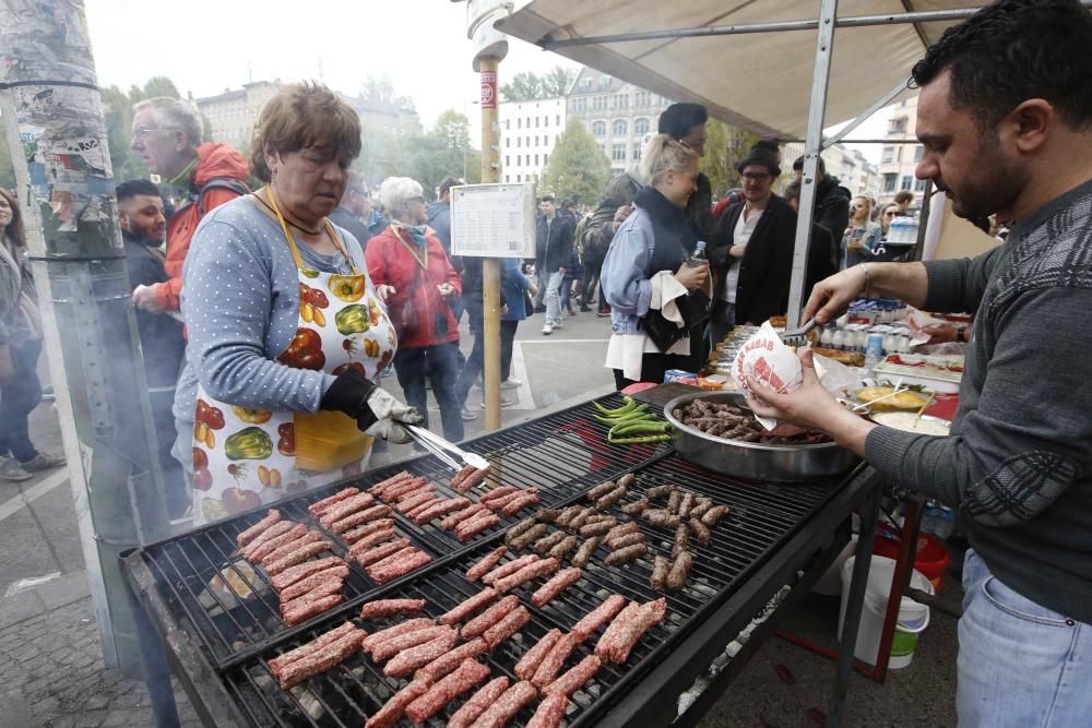 A woman grills sausages at the traditional ...