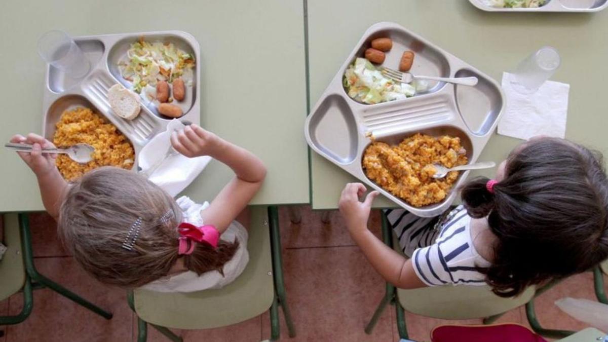 Dos niñas degustan degustan sus platos en el comedor del colegio en una imagen de archivo.