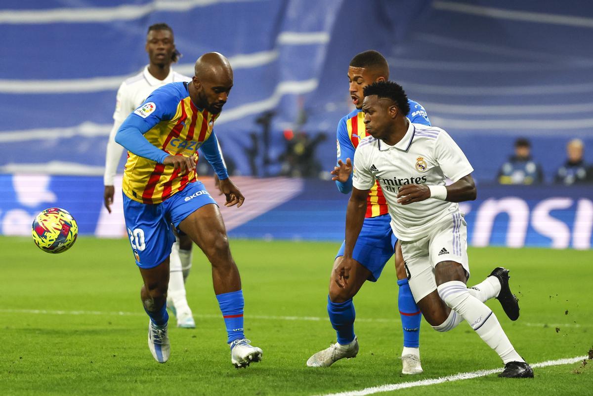 MADRID, 02/02/2023.- El delantero del Real Madrid Vinicius Jr. (d) lucha con el francés Dimitri Foulquier (i), del Valencia CF, durante el partido de la jornada 17 de LaLiga que Real Madrid y Valencia CF disputan este jueves en el estadio Santiago Bernabéu. EFE/Juanjo Martín