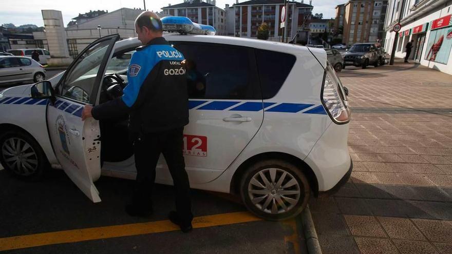 Un agente, ayer, entra en un vehículo junto a la sede de la Policía Local de Gozón.