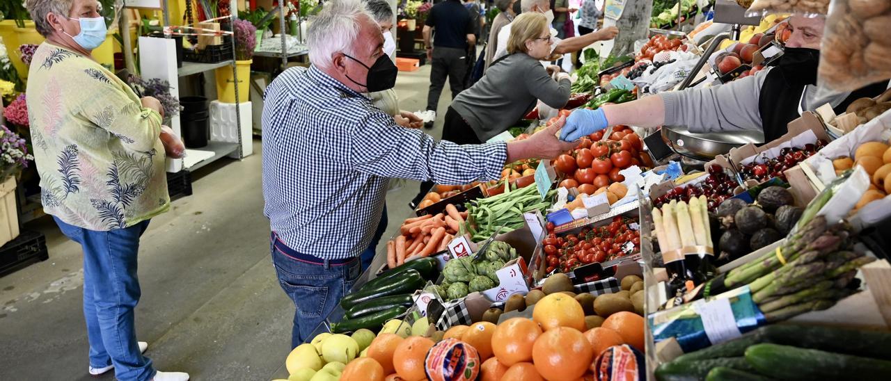 Clientes y vendedoras a mediodía de ayer en una frutería de la Plaza de Abastos.