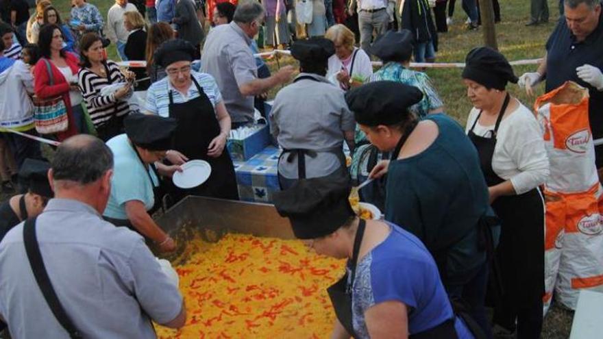 El reparto de paella en el prau de la fiesta de El Carbayu.