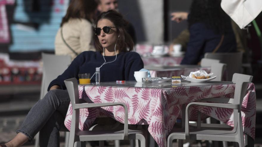 Una mujer disfruta en una terraza en Madrid.
