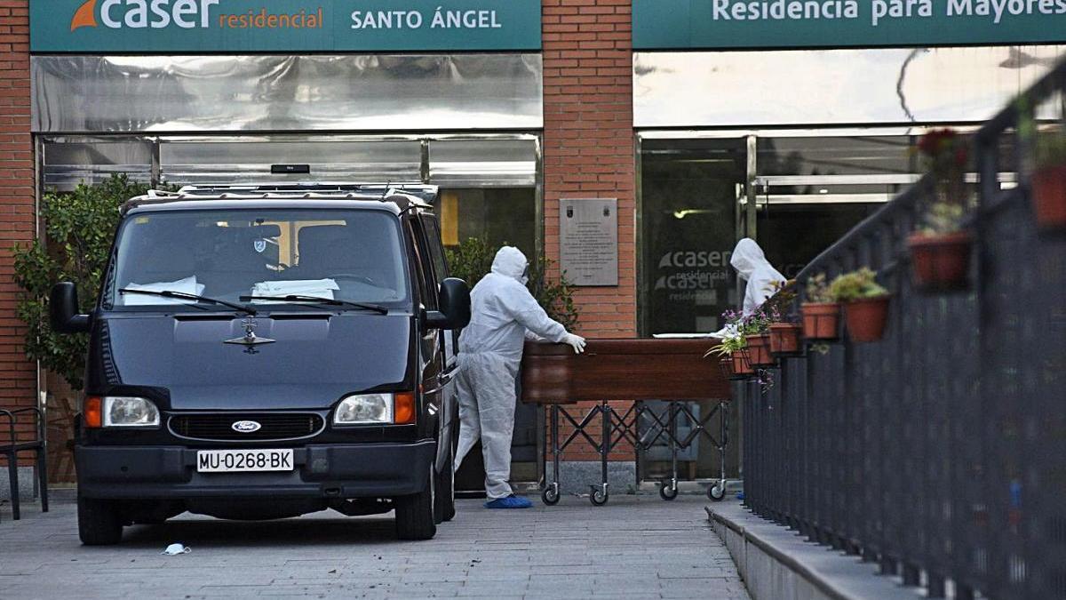 Servicios funerarios trasladan a un fallecido en una residencia en marzo de 2020.