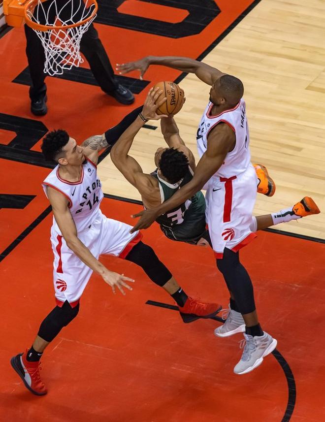 Danny Green (i) y Serge Ibaka (d) de Toronto Raptors en acción ante Brook López (c) de Milwaukee Bucks, durante el cuarto juego para los finales de la Conferencia Este de la NBA.