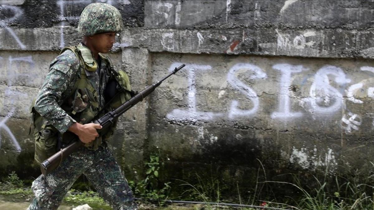 Un soldado filipino patrulla por un vecindario despues de un bombardeo durante los combates contra el EI.