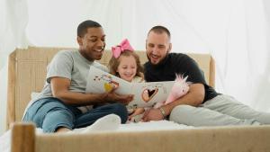 Unos padres leyendo un libro con su hija.