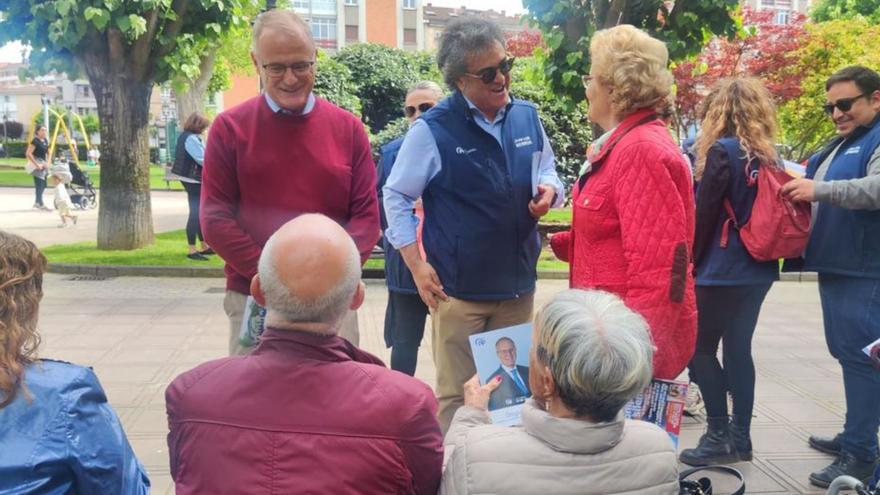Por la izquierda, Diego Canga y Juan Luis Berros, repartiendo publicidad del PP en el parque de Pola de Siero.