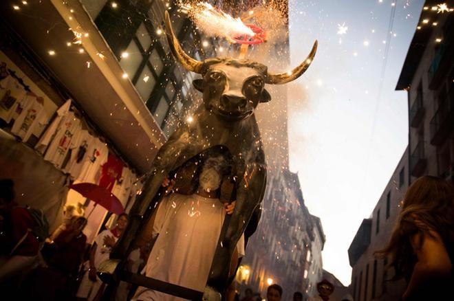 Un hombre que lleva un disfraz de Toro de Fuego (toro de fuego) persigue a personas durante la Fiesta de San Fermín, en Pamplona, norte de España.