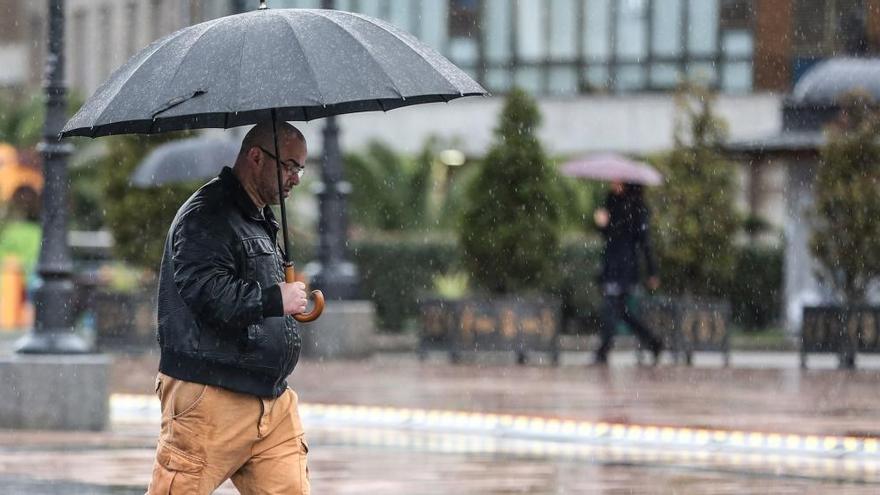 Un hombre bajo la lluvia en Oviedo