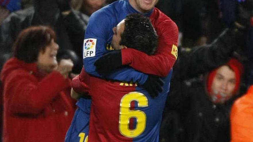 Messi se abraza a Xavi tras uno de los goles. / albert gea