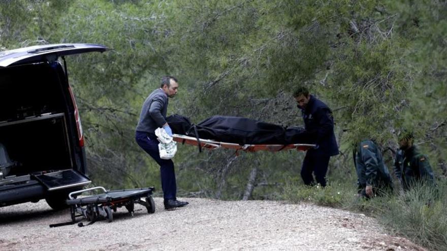 Dos trabajadores trasladan los restos mortales del hombre al Instituto de Medicina Legal.