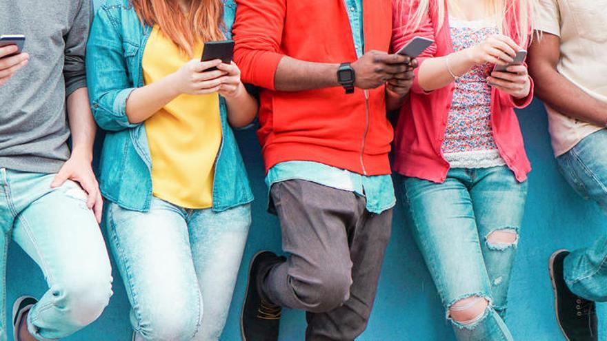 Un grupo de jóvenes con sus teléfonos.