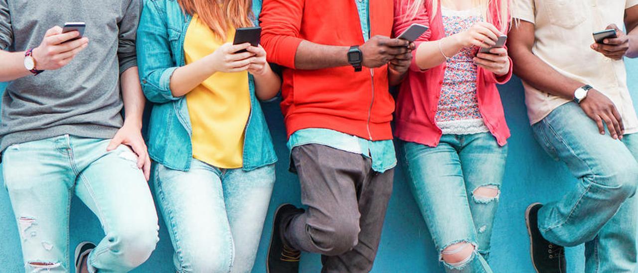 Un grupo de jóvenes con sus teléfonos.