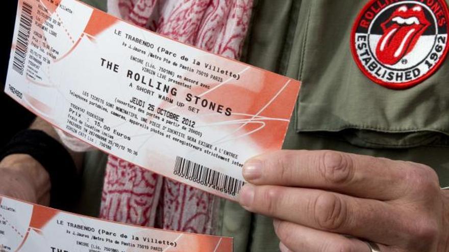 Un afortunado enseña dos entradas para ver a The Rolling Stones en París.