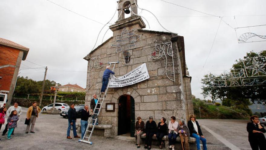 Un grupo de feligreses colgó ayer la pancarta en la fachada de la capilla de A Merced. // Marta G. Brea