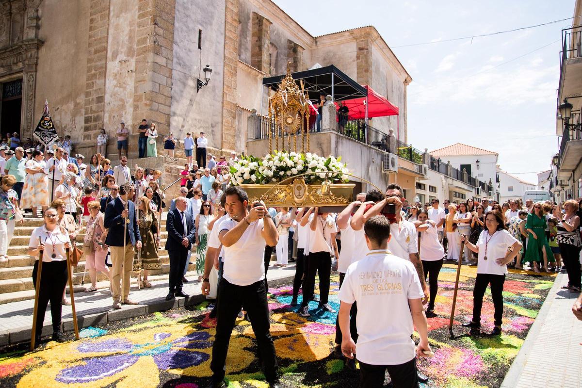 La custodia del Corpus Christi pasa por las coloridas alfombras de virutas de corcho de San Vicente de Alcántara.