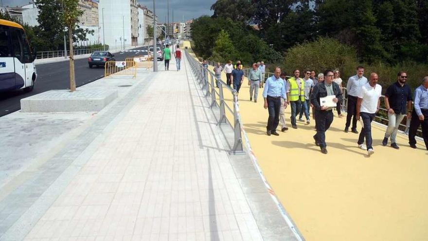 Políticos y técnicos recorren el sendero peatonal del cauce de Os Gafos, paralelo a la nueva avenida de Josefina Arruti. // Rafa Vázquez