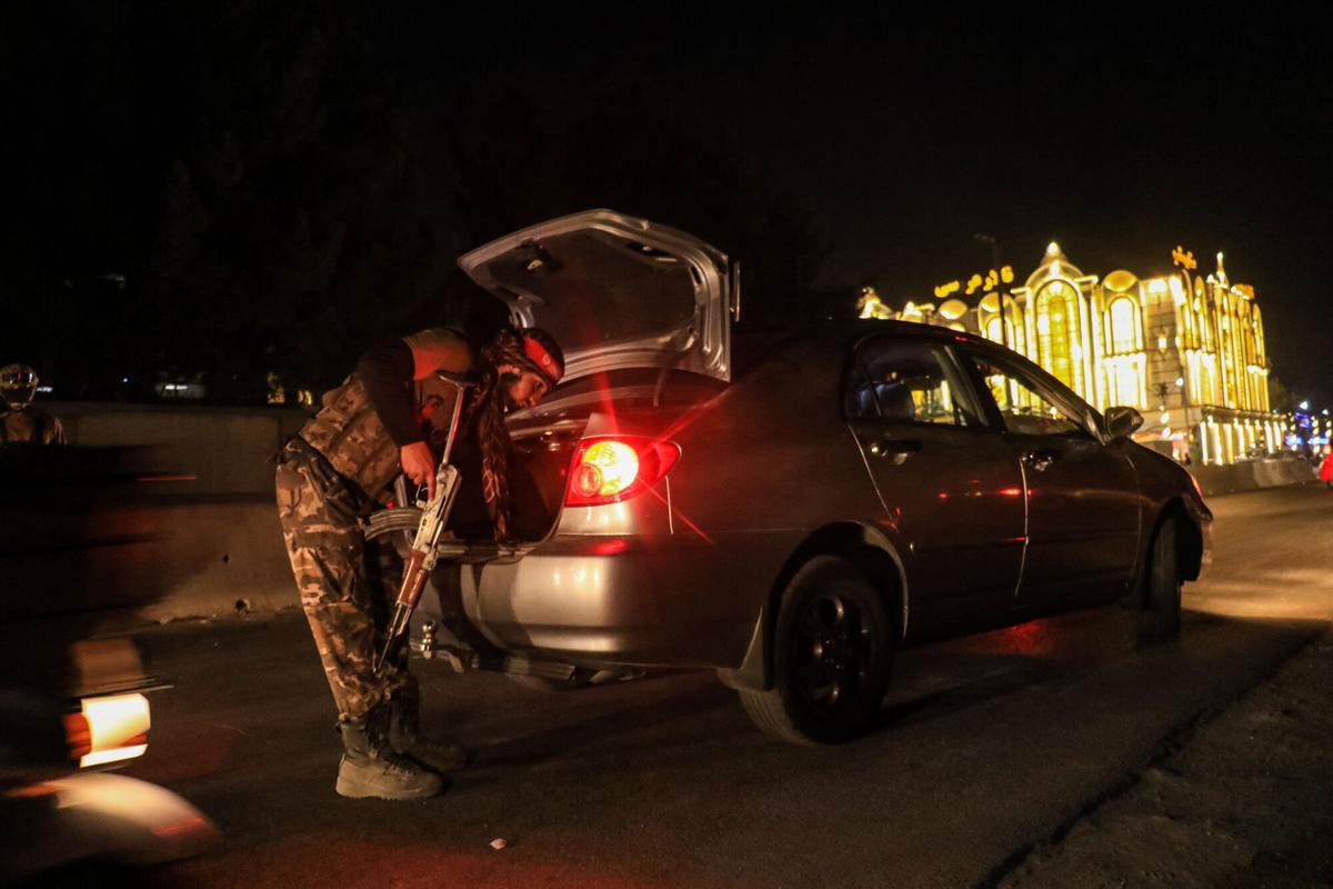 Un agente de seguridad talibán inspecciona un coche en un punto de control en Kabul, Afganistán, la noche del 26 de febrero. Un agente de seguridad talibán inspecciona un coche en un punto de control en Kabul, Afganistán, la noche del 26 de febrero.