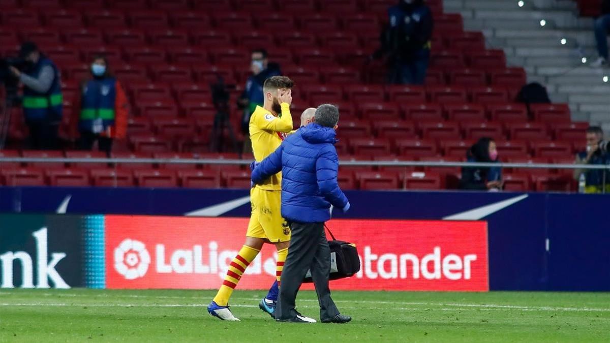 Piqué abandona lesionado el Metropolitano junto a Lluís Til, el médico del Barça.