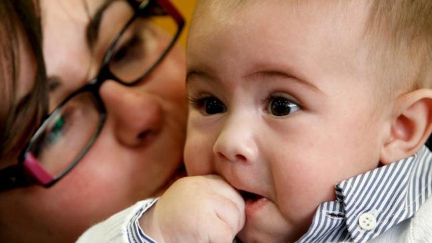 Juan, el primer bebé del mundo seleccionado con el EmbryoScope, un incubador que permite observar al embrión desde el momento de la fecundación in vitro hasta su transferencia al útero, en brazos de su madre durante la rueda de prensa en la que contó hoy la historia de su hijo, nacido en Valencia el pasado 4 de junio.