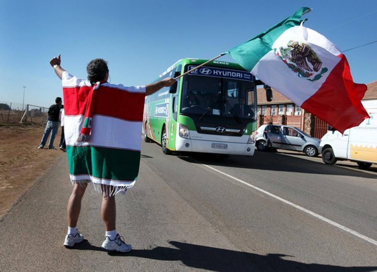 Un aficionat saluda els jugadors de la selecció mexicana que arriben en autobús a la sessió d’entrenament al Waterstone College de Johannesburg.